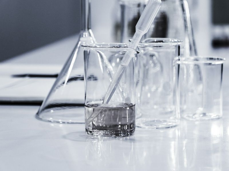 Clear glass beakers on a white laboratory bench